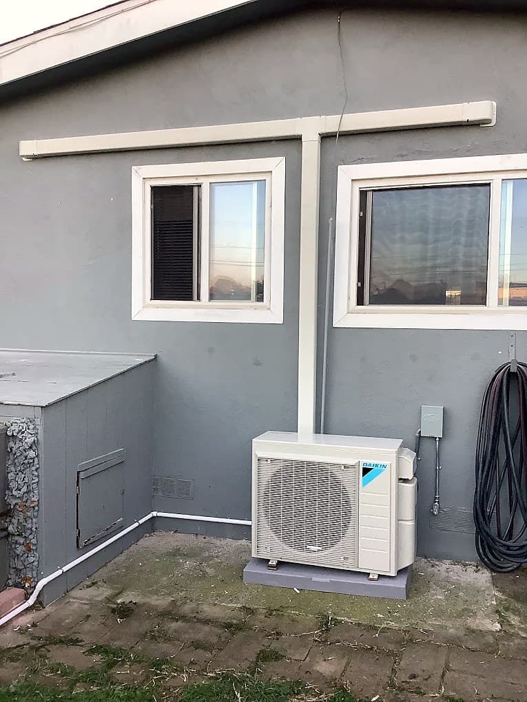 Mini-split outdoor unit on a grey stucco home